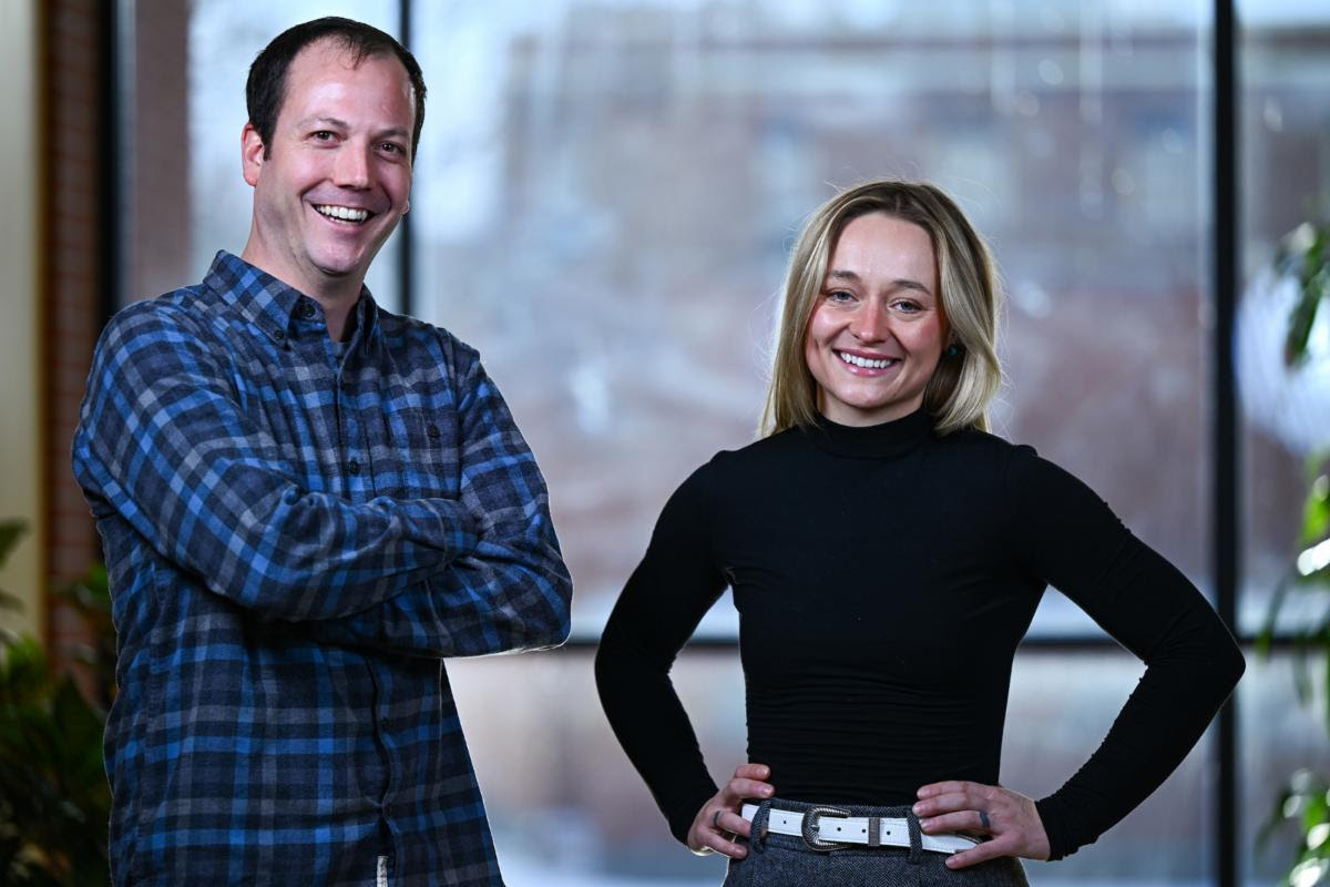 Alex Clark, a white man with a blue plaid button-down shirt to the left of Gillian Ellison, a blonde white woman with a black long-sleeved shirt.